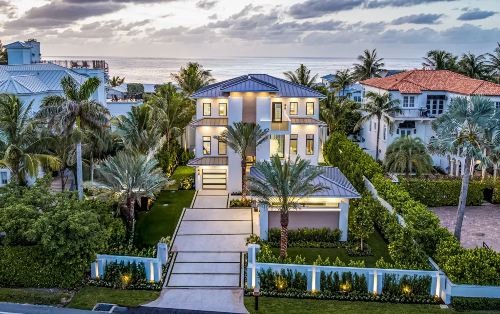 Contemporary home exterior with custom concrete driveway and pool deck finished in natural shell broadcast texture
