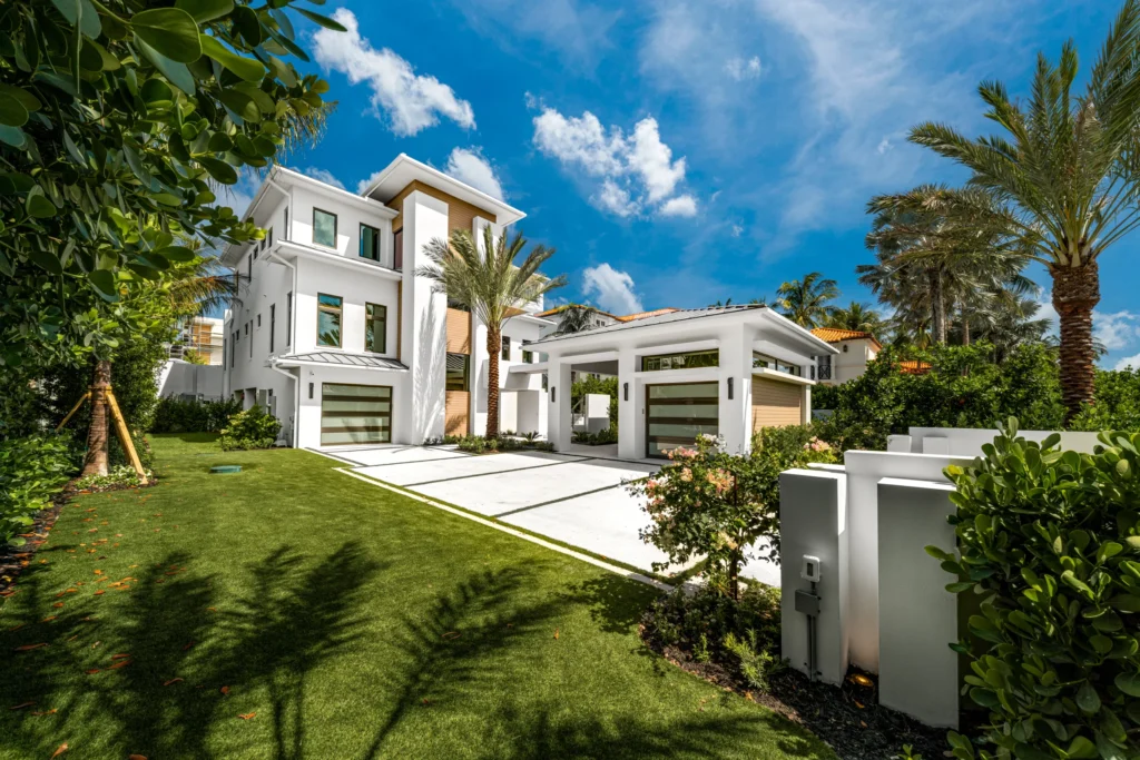 High end coastal home with custom concrete driveway featuring a sandblasted shell broadcast surface