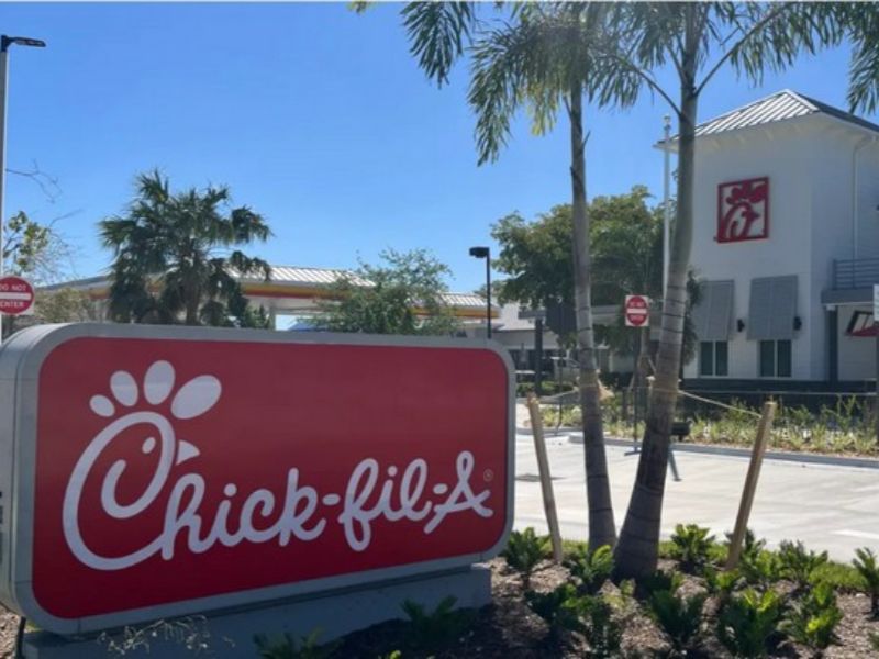 Commercial concrete sidewalks and curbing featured at the entrance drive of a Chick‑fil‑A restaurant.