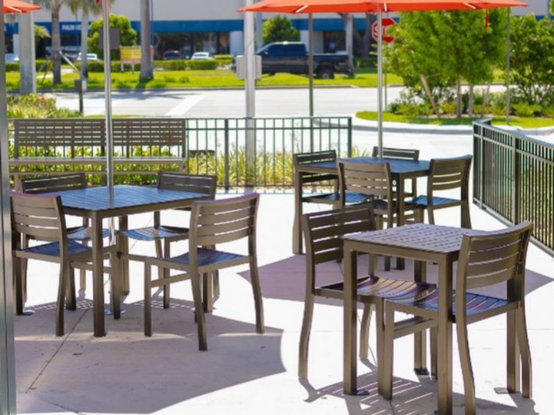 Restaurant seating area bordered by concrete sidewalks and clean curb lines